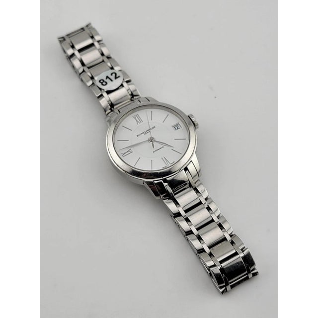 The Baume & Mercier Classima White Women's Watch - MOA10267 is a luxury dress/formal timepiece with a sleek silver...