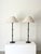 A pair of slim stemmed table lamps in the manner of Jacques Adnet, adorned with decorative turned metal rings inspired by...