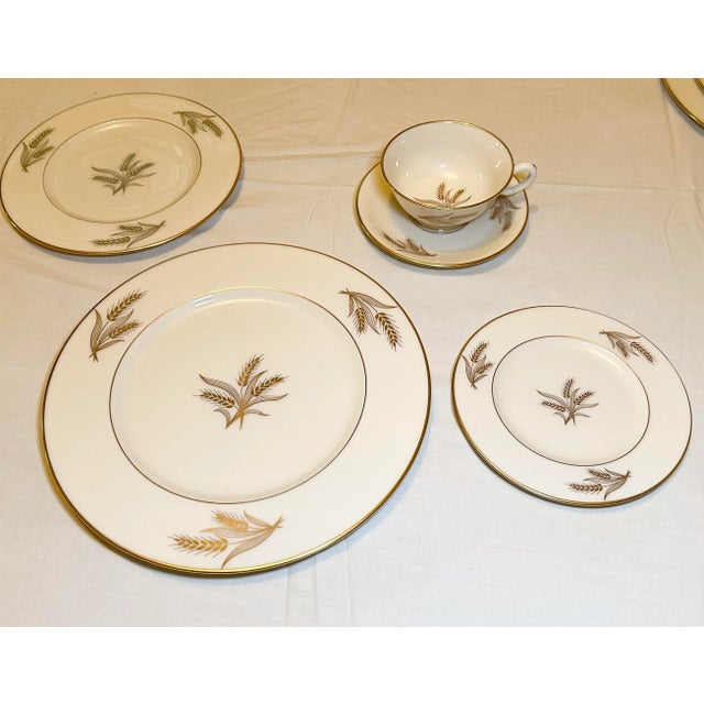 A 42-piece Lenox Harvest china dinnerware service for eight, decorated with a wheat motif and gold trim. The set includes:...