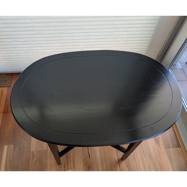 Black oval high occasional wooden table no. has lower shelf. age approximately 30 years. Table top width 30", depth 20",...