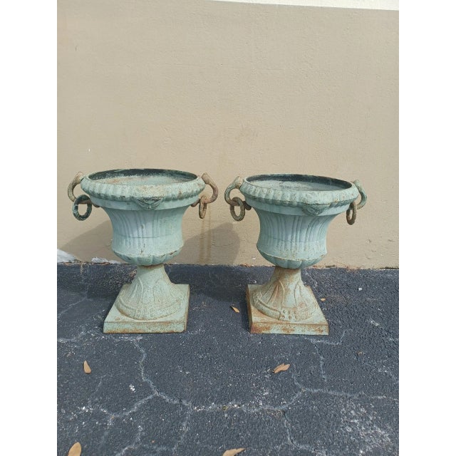 Heavy pair of antique cast iron green urns. Acquired from a Palm Beach estate