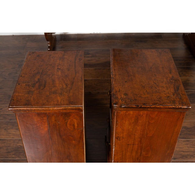 A pair of Italian walnut commodini from the mid-19th century, with three drawers and bun feet. This pair of mid-19th...