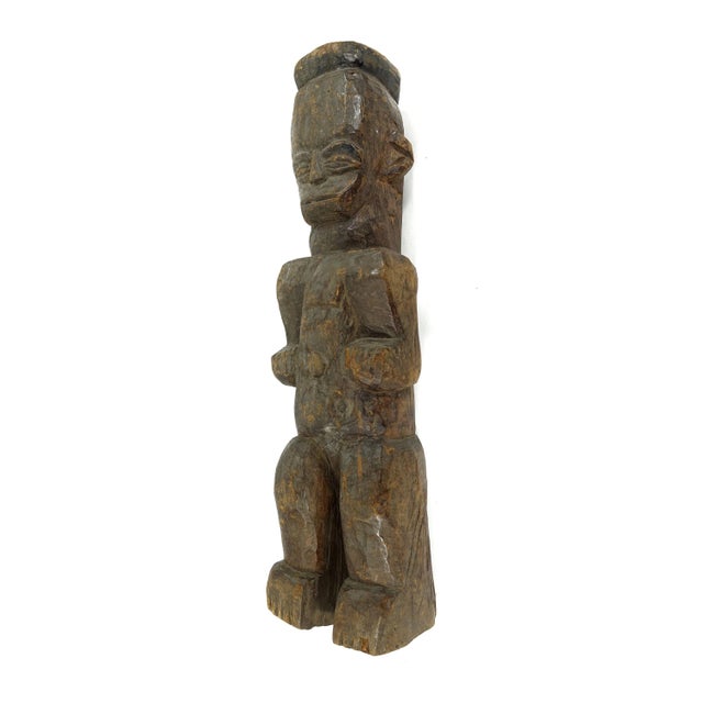 A standing figure with large head identified as an Urhobo figure from Nigeria at a crossroads of cultural and artistic...