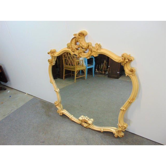 French Rococo style mirror, fancy detailed frame with cream and gilt finish.