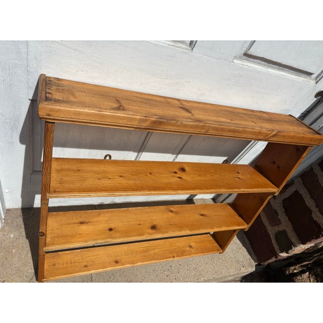 Turn of the century unfinished pine hanging bookshelf.
