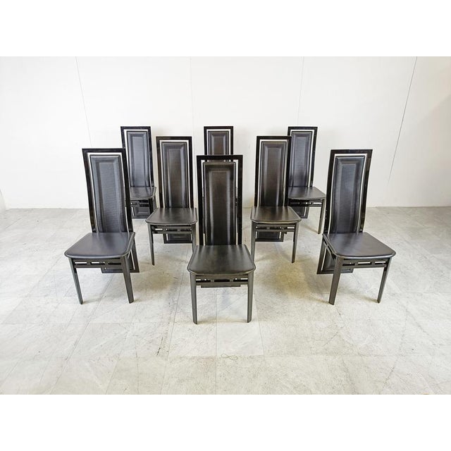 Set of 8 highback dining chairs with black lacquered wooden frames and leather seats and backrests. The back curves down...