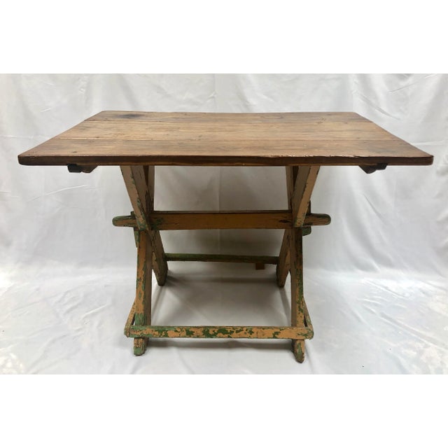 Antique hand crafted trestle table. Imported from France. The base is crafted from rustic wood and painted with layers of...