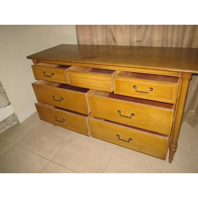 The Vintage 7 Drawer Dresser by Bassett Furniture from the 1960s exudes a timeless charm with its light wood tone finish...
