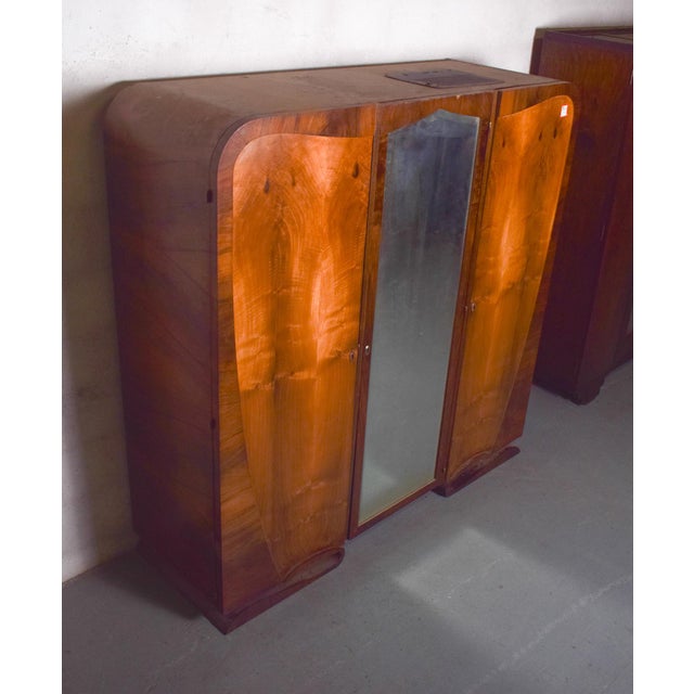 This elegant Art Deco wardrobe, crafted in walnut, reflects the clean lines and refined style of the early 20th century....