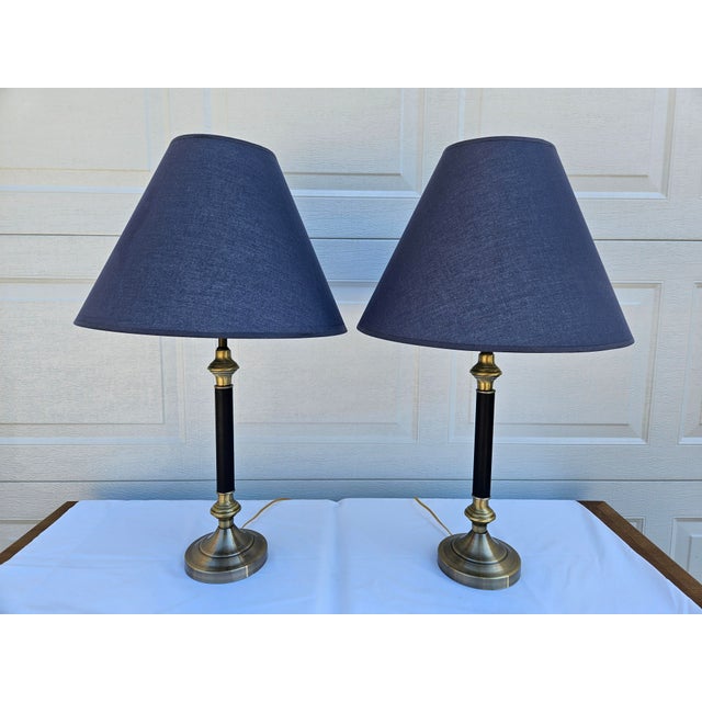A classic pair of brass and navy-blue table lamps with matching blue shades. This pair of lamps are in very good vintage...