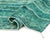 A rug that moves like water — horizontal bands of emerald and blue melt into one another, threaded through with fine cream...