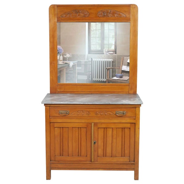 This early 20th-century Art Nouveau vanity cabinet is made of hand-carved solid cherrywood with a beveled mirror and a...