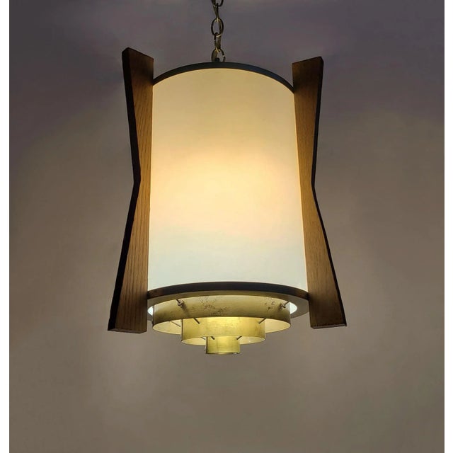 This pair of matching pendants have three wood fins outside of the large, polyethylene drum diffusers. Floral rivets...
