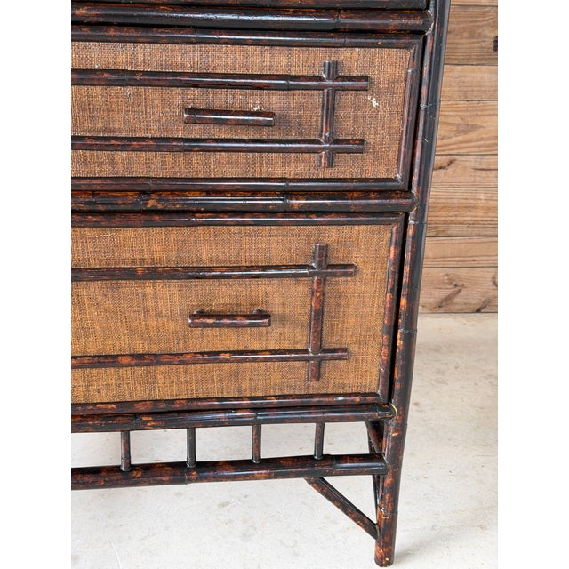 A striking vintage armoire cabinet showcasing classic British Colonial style with faux bamboo detailing and richly...