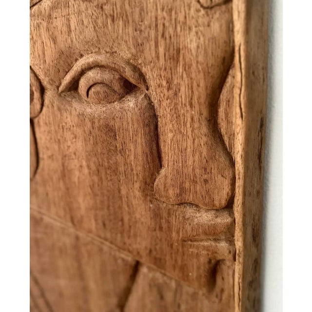 This mid-century carving presents a calm, enduring figure rendered in warm, textured wood. The relief’s depth and patina...