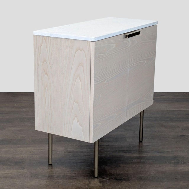 The cabinet has a solid marble top and a solid poplar wood frame with a wood veneer. It is covered in a water-based finish...