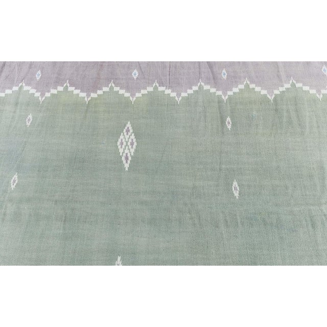This vintage 1945 Indian Dhurrie rug is a refined example of mid-20th-century flat-weave craftsmanship, distinguished by...