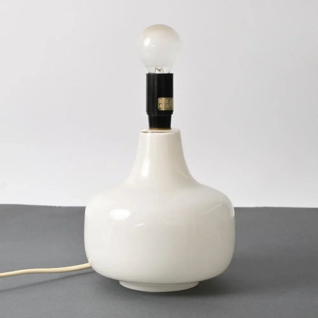 1980s Danish white glass table or bedside lamp. Similar to the pieces made by Holmegaard. It uses one bulb, type E14....