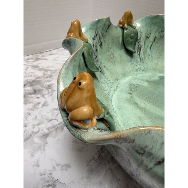 Large whimsical pottery called bowl in a lush turquoise or aqua drip glaze, textured leaves and gold frogs! So cute. It’s...