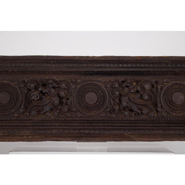 Carved wooden panel originating from Chettinad, Tamil Nadu, decorated with deeply carved motifs combining mythical...