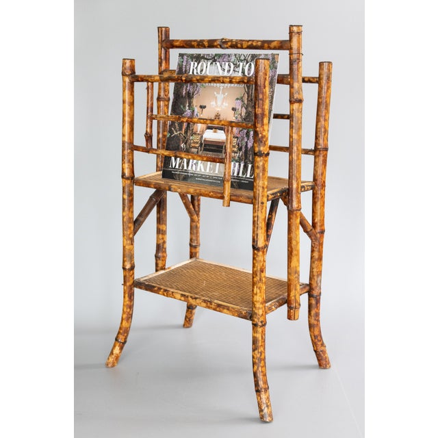 A superb antique English bamboo tiered magazine rack with woven grasscloth lower shelf, circa 1880. This magazine rack is...