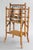 A superb antique English bamboo tiered magazine rack with woven grasscloth lower shelf, circa 1880. This magazine rack is...