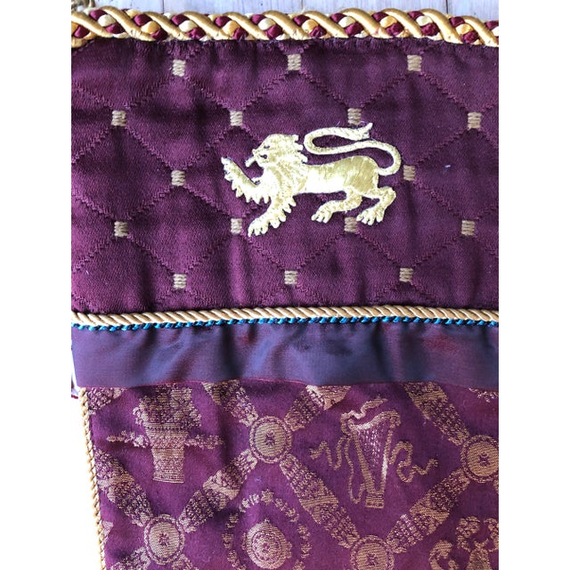 Burgundy and gold Christmas stocking with an embroidered metallic gold lion. Reverse is quilted striped solid burgundy...