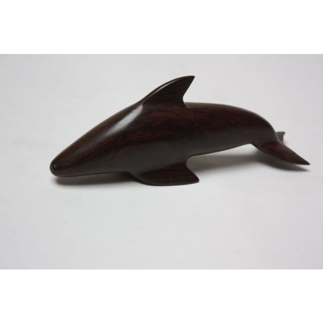 Carved dolphin circa 1970s sculpted from iron wood (an extremely dense wood, resembling rosewood in color and grain,...