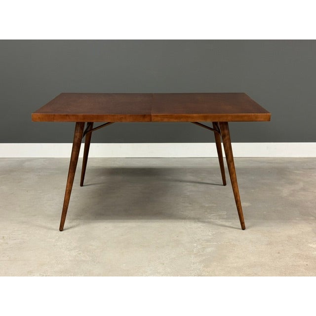 A mid century modern maple dining table designed by Paul McCobb for Winchendon’s Planner Group. One 15” leave which fully...
