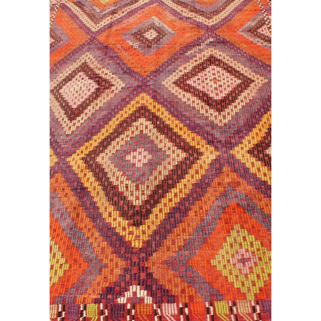 Measures: 5'7 x 10'5. Featuring a large diamond pattern with a spotted and speckled assortment of geometric checkered...