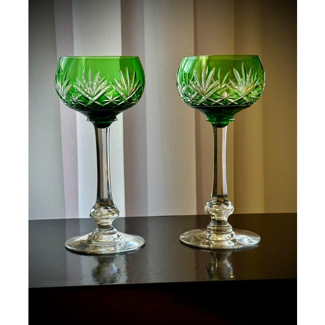 A pair of french saint-louis massenet crystal hock wine glasses with green cut-to-clear bowls, estimated to date to the...