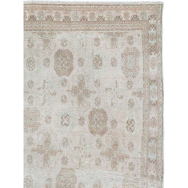 This mid-20th-century Turkish Anatolian accent rug presents a softly ordered allover pattern across a pale ivory and warm...