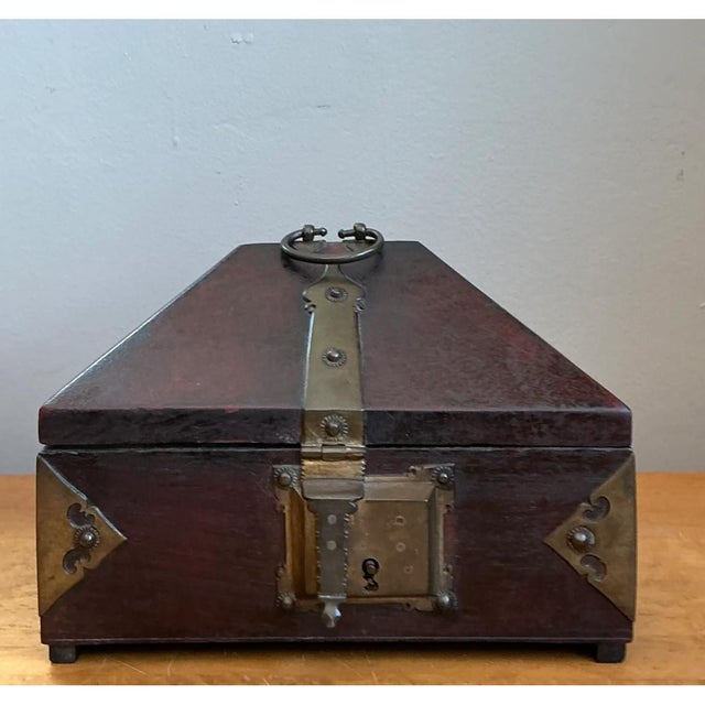 Crafted from rich wood and brass-toned metal hardware, this vintage decorative box showcases a distinctive pyramid-shaped...