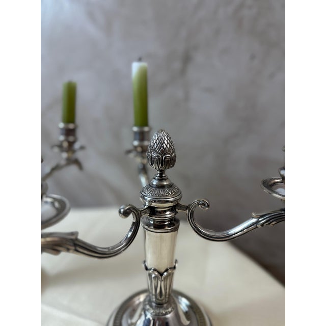 An elegant pair of four-arm silver-plated metal candlesticks dating from the 1940s, with a refined design inspired by...