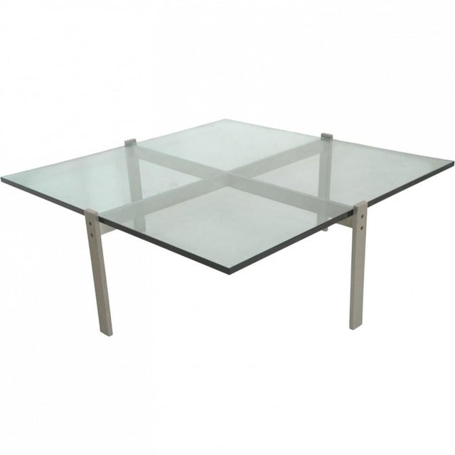 Poul Kjærholm PK65 glass coffee table with a steel frame. The table is from the 2000s and appears with some scratches on...