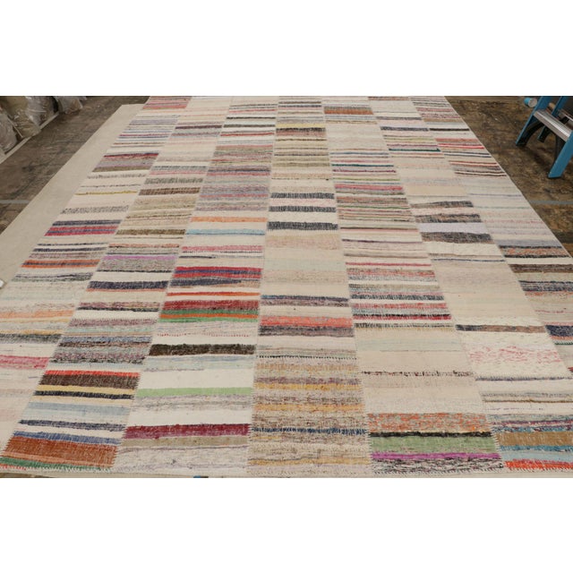 Handwoven in wool, this 10x14 oversized modern Kilim rug from Rug & Kilim’s Patchwork Kilim rug collection marries...