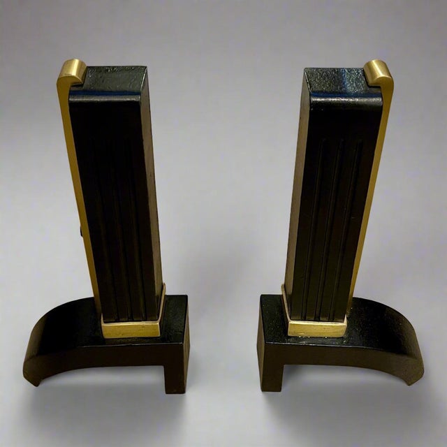 A pair of handsome modern Art Deco period andirons from France circa 1930. Each piece is made of heavy cast iron and...
