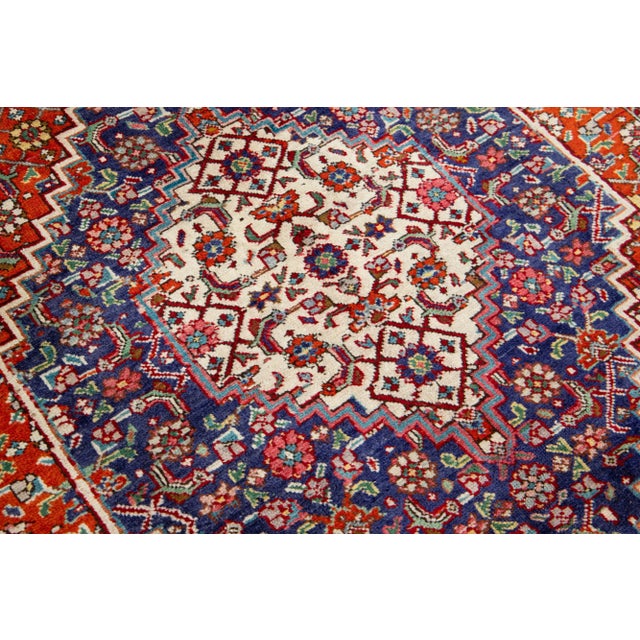 A beautiful vintage Tabriz hand-knotted wool rug with a red and navy blue field. This piece has multicolor accents and an...