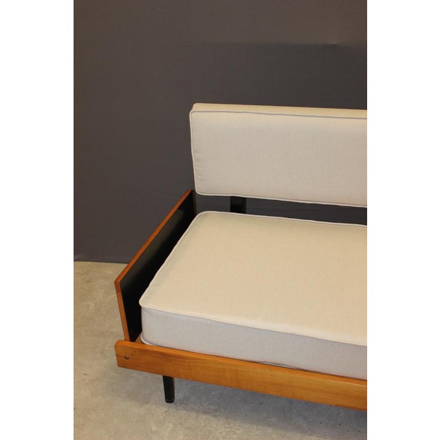 Three-seater sofa, structure in cherry wood and black lacquered wood, the backrest is tiltable, front legs in black square...