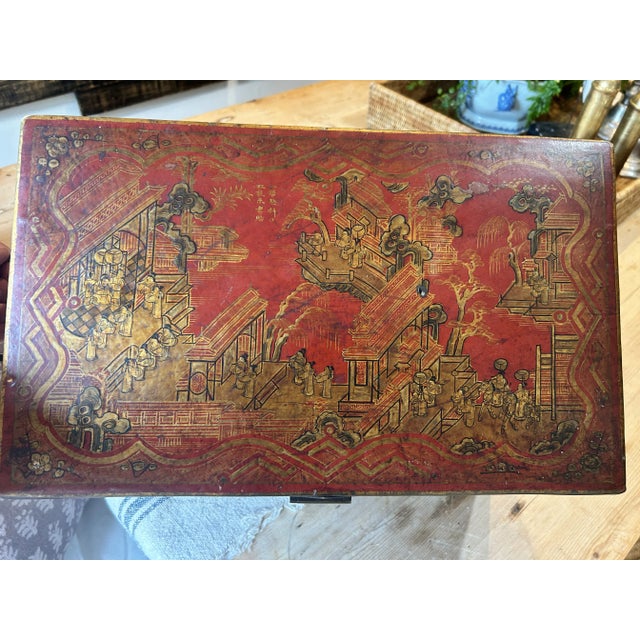 Such a beautiful example of a Chinese red lacquered leather box. Gilded decorative scenes, temples, families, ancestors on...