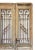 Pair of antique late 19th century rustic wooden entrance doors with wrought iron window grilles. Distressed finish...