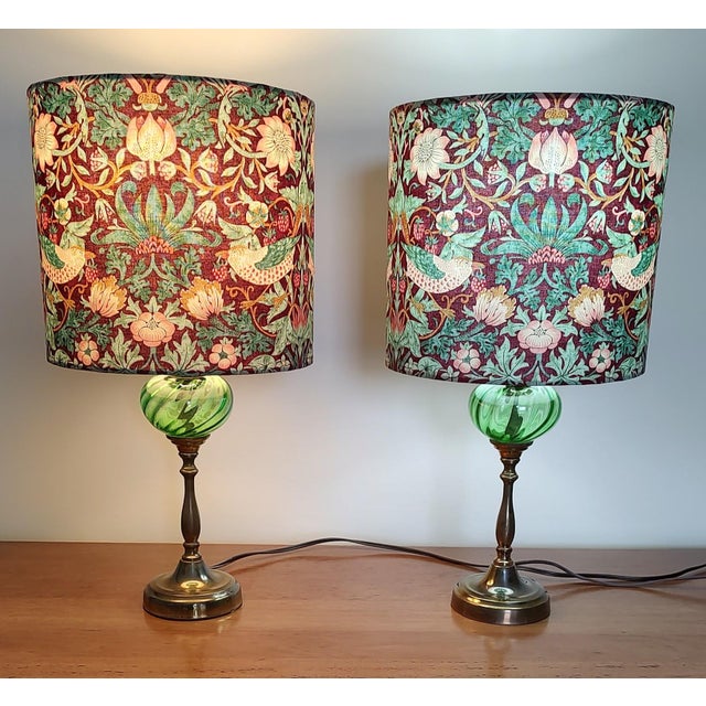 Beautiful pair of vintage lamps featuring green glass globes with brass base. These lamps have been paired with lampshades...