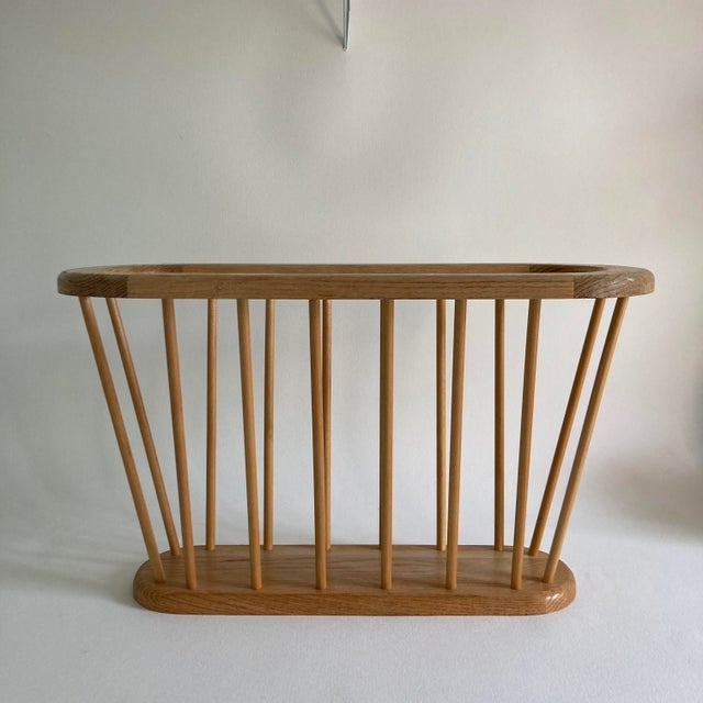 A solid, blonde wood magazine rack featuring 16 spindles and a wide, wood rim. A fun, modern yet classic form that is...