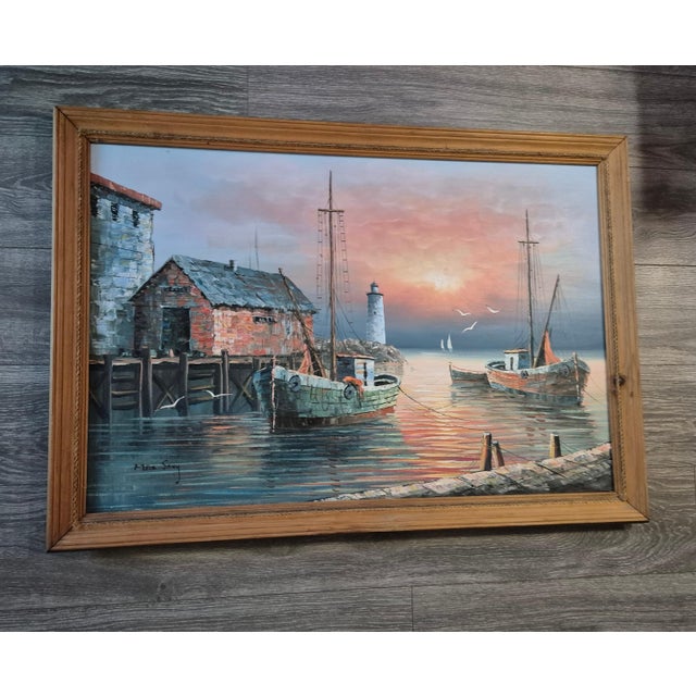 This oil painting depicts a tranquil harbor scene at sunset, framed in a rustic wooden border. Key Visual Elements Central...