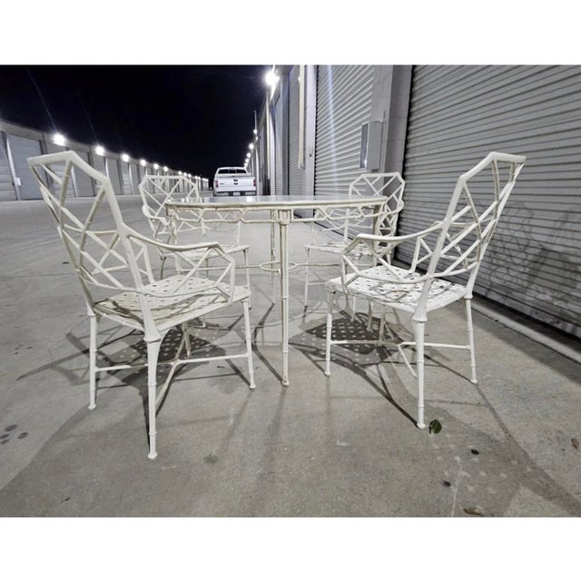 The Vintage Brown Jordan Calcutta Dining Set includes four white indoor/outdoor dining armchairs and a matching table, all...