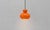 A striking vintage pendant light by peill & putzler from the 1970s. The bulbous lampshade, made of vibrant orange opal...