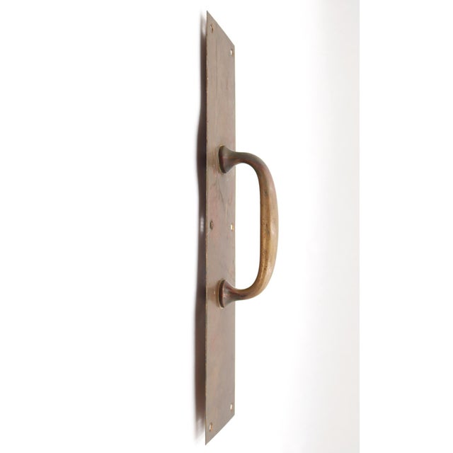 Commercial style door pulls made of brass with a patina finish. The original mounting screws are not available. Good...