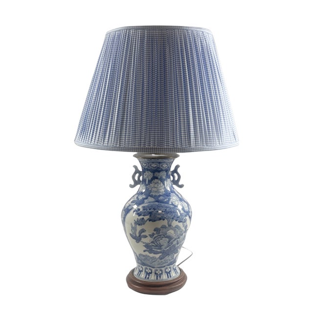 Chinese Blue/ White vase depicting floral garden motif. Size: 16" tall to base of lamp, 8" diameter. Age unknown.