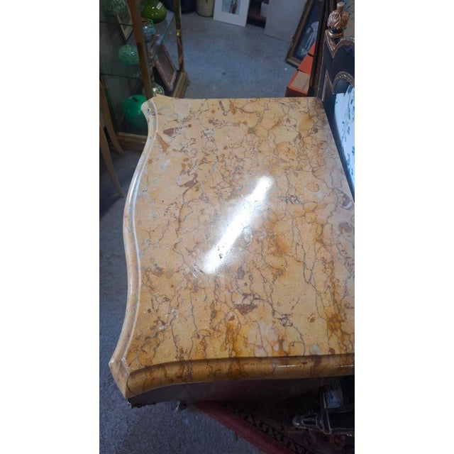 A Louis XV style marquetry chest of drawers with a marble top. It rests on five drawers. The marquetry is in perfect...