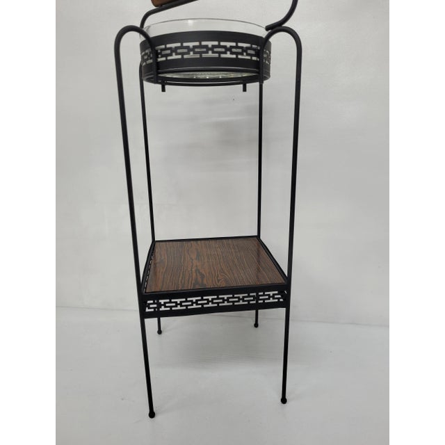 Vintage smoking stand from the Mid Century Modern Era in good condition. Stand is made of metal with a glass ashtray and a...